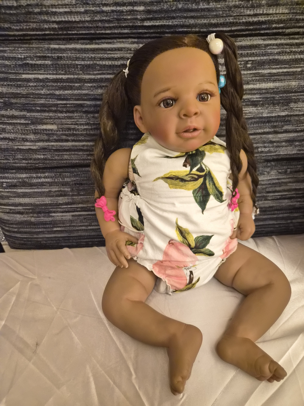 Reborn brown baby doll with pink and white floral outfit
